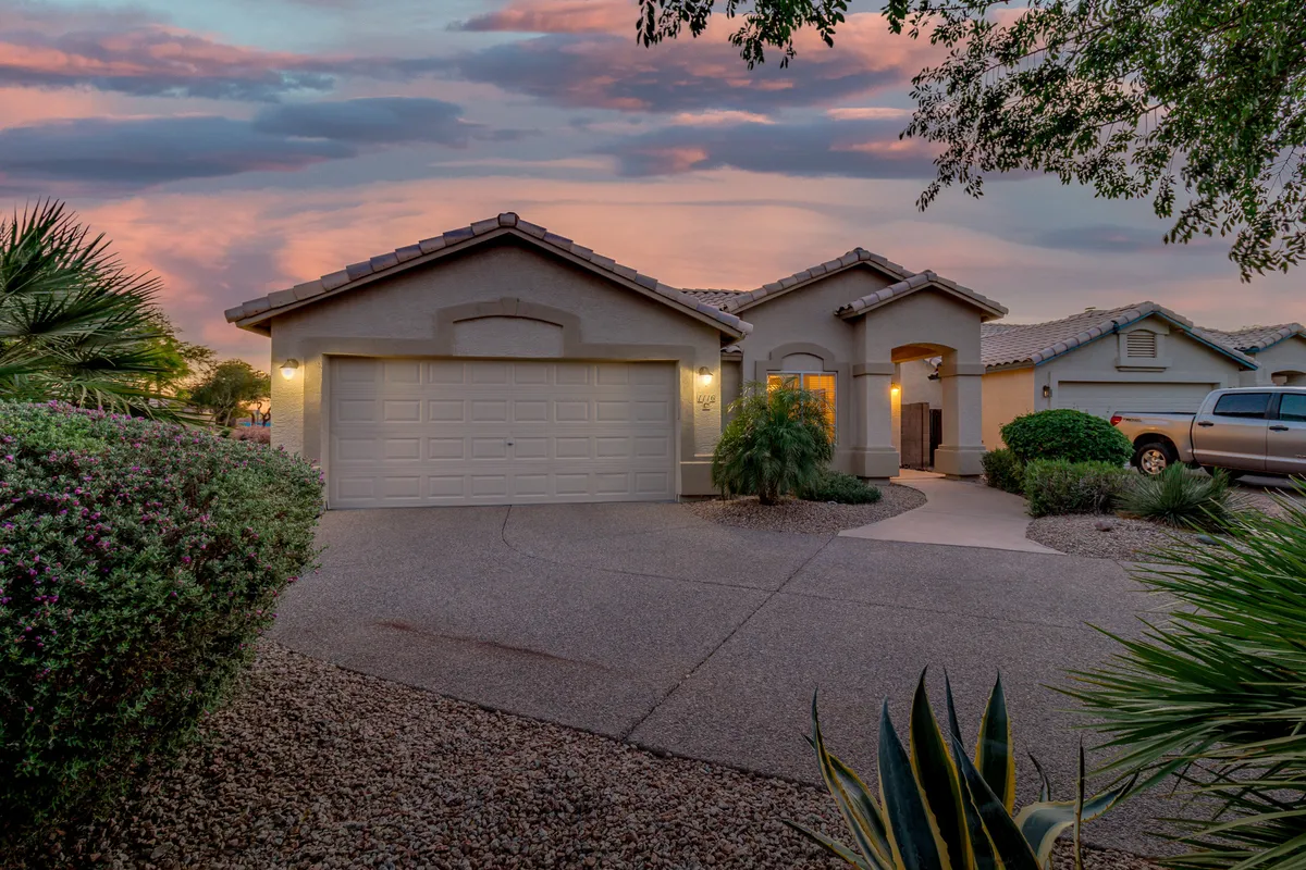 The photo captures a welcoming exterior view of the home, featuring a well-maintained landscaped front yard, a prominent garage door, and a spacious entryway. The setting is ideal for outdoor relaxation, evening gatherings, and enjoying neighborhood connections.